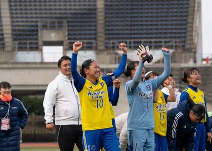 ベンチ前で両手を上げて喜ぶ選手とスタッフ